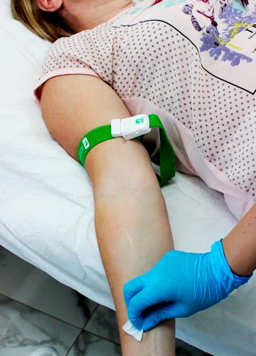 Врач собирается поставить капельницу пациенту